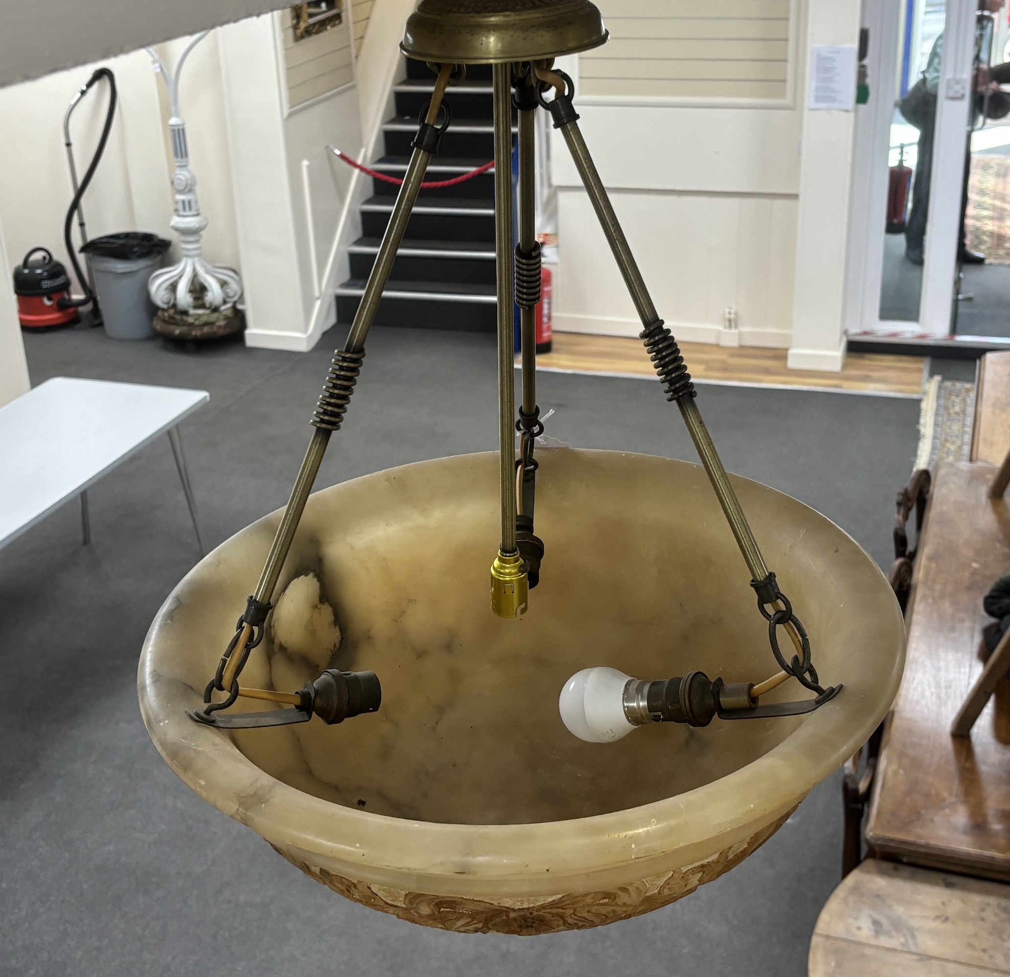 An early 20th century sculpted alabaster and brass plafonnier with four lamp fittings, diameter 46cm